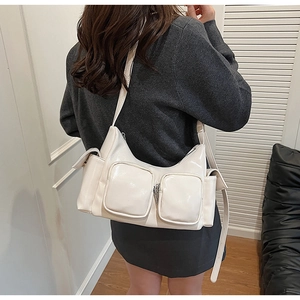 Detailed side view of a white glossy PU shoulder bag with functional multi-zipper pockets
