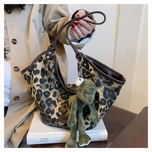 Détail du sac cabas à imprimé léopard avec bordure en cuir et pendentif en peluche