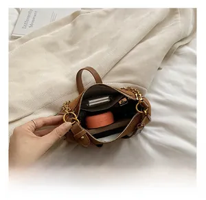 Detail view of mini brown PU leather bag interior with golden zipper and vintage texture