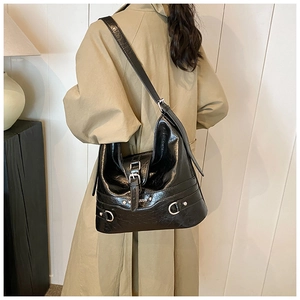 Detail shot of a black PU hobo bag with silver hardware and M STUDIO metal logo plaque