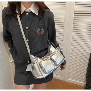 Detail view of silver metallic multi-pocket crossbody bag with high-shine texture