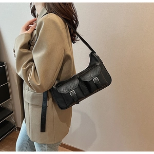 Detail der schwarzen PU-Schultertasche mit zwei Fronttaschen und Metallschnallen