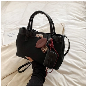 Fashionable black PU leather and canvas tote bag with decorative charms and metal twist lock