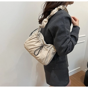 Dettaglio della borsa a tracolla in nylon beige a pieghe con spallina a volant