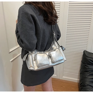 Detail view of a large silver metallic PU shoulder bag with functional multi-pocket design