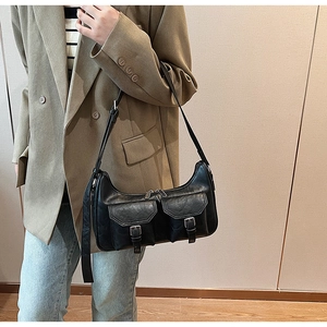 Detail der schwarzen PU-Leder-Schultertasche mit doppelten Pattentaschen und Metallschließen