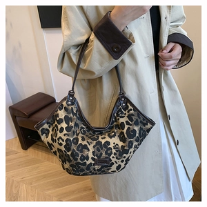 Détail du sac hobo tendance à imprimé léopard avec bordure en cuir marron et logo en métal