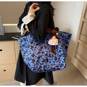 Close-up of a large shoulder tote bag with blue animal print and cute mouse charm