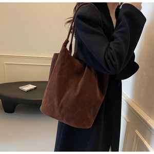 Detail view of coffee brown faux suede tote bag on shoulder for casual styling