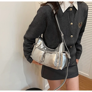 Detail of silver metallic PU shoulder bag showing functional zippers and shiny texture