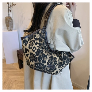 Détail d'un sac cabas à imprimé léopard avec bordure en cuir et rivets métalliques