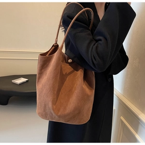 Detail view of brown suede leather texture and stitching on large minimalist tote bag