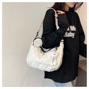 Dettaglio della borsa a mezzaluna in nylon trapuntato bianco con mini pochette e ciondolo