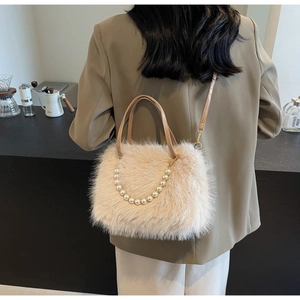 Detail of plush faux fur crossbody bag in apricot with pearl chain and leather strap