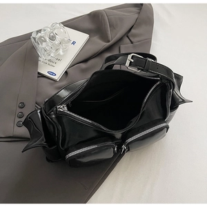 Detailed macro view of black glossy PU leather texture and premium zipper pockets on the bag