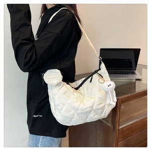 Dettaglio della borsa hobo bianca trapuntata con mini astuccio e ciondolo peluche
