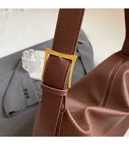 Détail du sac en cuir PU caramel avec boucle dorée vintage et texture grainée élégante