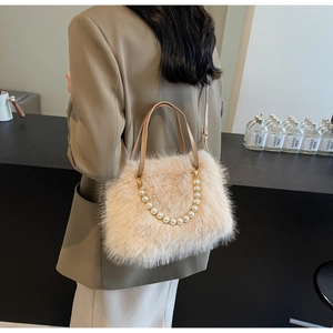 Detail of plush faux fur handbag featuring elegant pearl handle and leather strap