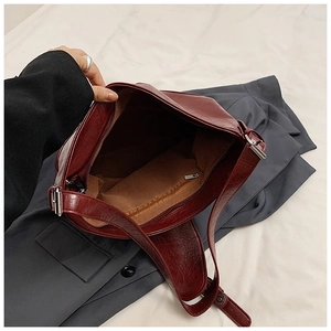Detail view of burgundy PU leather shoulder bag showing zipper closure and inner lining