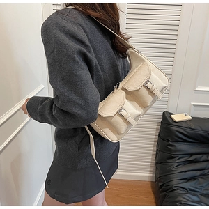 Detail der cremeweißen PU-Schultertasche mit Cargo-Doppeltaschen und Metallschnallen