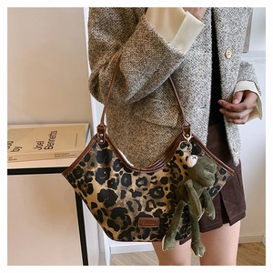 Détail du sac cabas imprimé léopard avec bordure en cuir et porte-clés grenouille verte
