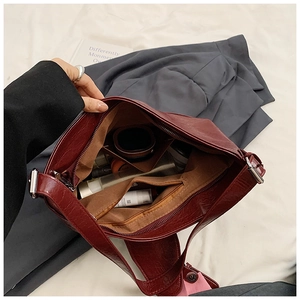 Internal view of dark red PU leather tote showing brown lining and zippered pocket