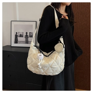 Dettaglio borsa a mezzaluna trapuntata bianco off-white con portamonete e ciondolo