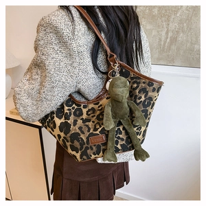 Détail du sac cabas en toile léopard avec bordure en cuir et charmant porte-clés grenouille