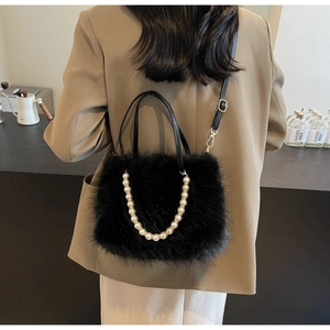 Detail of black faux fur handbag with white pearl chain and slim leather shoulder strap