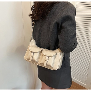 Detail der cremefarbenen PU-Leder Schultertasche mit Vintage-Schnallen und Klappentaschen