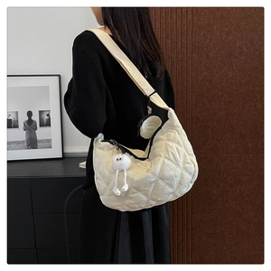 Dettaglio borsa a tracolla in nylon trapuntato bianco crema con mini pochette e peluche