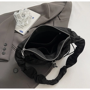 Dettaglio interno della borsa a tracolla in nylon nero con cerniera argento e tasca