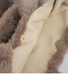 Détail de la boucle magnétique dorée sur doublure en cuir beige et bordure en fausse fourrure
