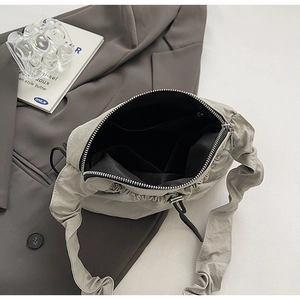 Dettaglio della borsa a tracolla in nylon grigio con fodera e zip in metallo