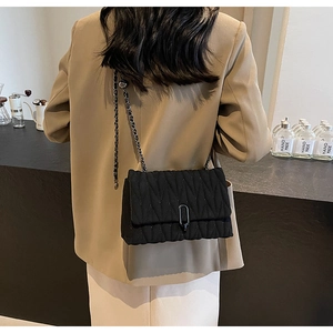 Detailed view of black quilted PU crossbody bag with elegant chain strap and metal lock