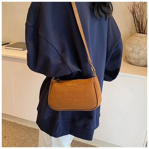 Brown crocodile pattern shoulder bag shown on model with MOKANI YOLE brand detail
