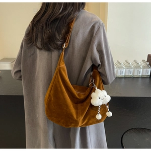 Brown suede half-moon shoulder bag with white plush cloud pendant and vintage aesthetic
