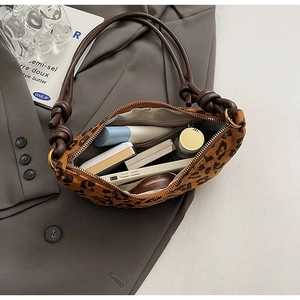 Détail du sac léopard montrant l'anse nouée et l'espace intérieur pour accessoires