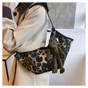 Détail du sac hobo à imprimé léopard avec un porte-clé en peluche grenouille verte