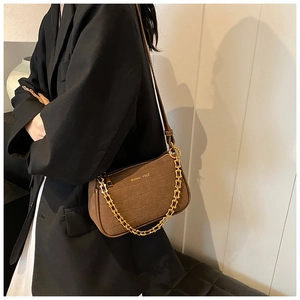 Detail of brown faux crocodile leather bag with gold chain strap and MOKANI YOLE logo