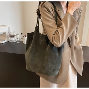 Close-up of matte dark green PU leather tote bag with long shoulder straps for daily commute