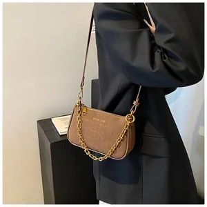 Detail of dark brown croc-embossed PU leather bag with a stylish chunky metal chain