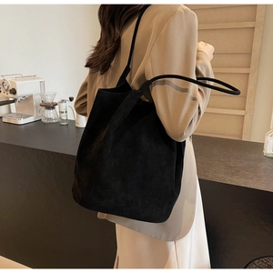 Close-up of matte black suede tote bag with long shoulder straps for daily commuting