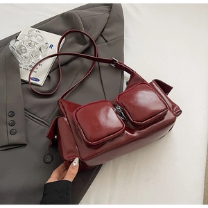 Minimalist wine red PU leather crossbody bag with multi-pocket design on casual blazer