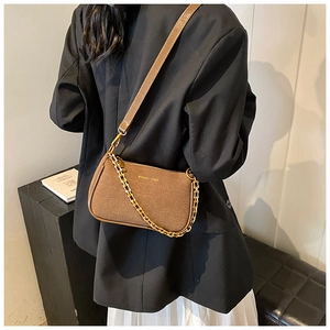 Detail of a brown croc-effect shoulder bag with golden chain and branding