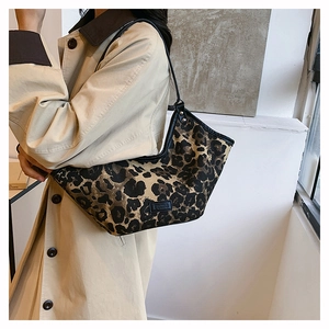 Détail de la texture léopard du sac hobo et du logo gumu sur l'étiquette noire
