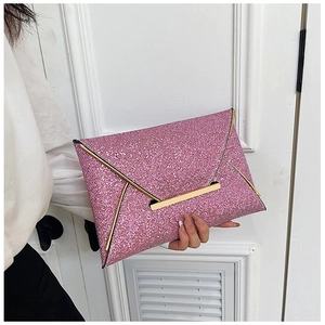 Gros plan d'une pochette enveloppe rose pailletée avec bordure dorée et texture scintillante unique