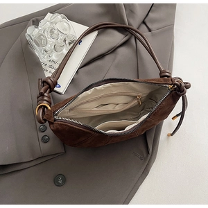 Vue détaillée de l'intérieur du sac demi-lune en daim marron avec compartiments de rangement
