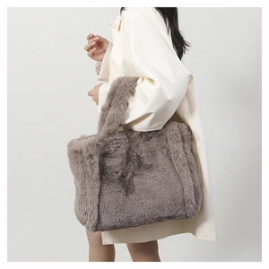 Détail du sac fourre-tout en fausse fourrure taupe montrant la texture et la poignée