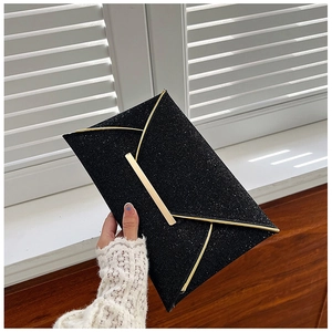 Détail d'une pochette de soirée noire pailletée avec bordure dorée élégante et texture fine
